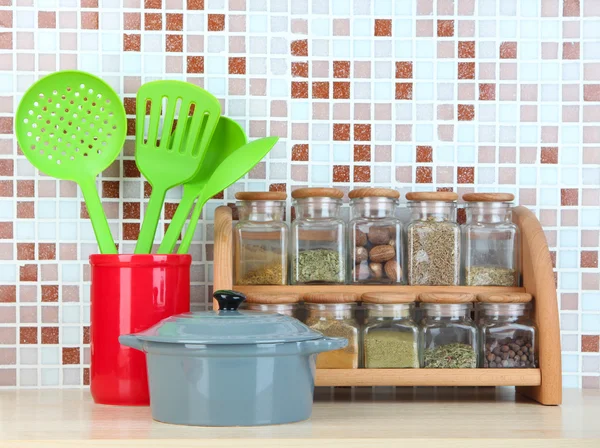 Conjunto de especiarias, utensílios de mesa e utensílios de cozinha na cozinha sobre a mesa em mosaico telhas de fundo — Fotografia de Stock