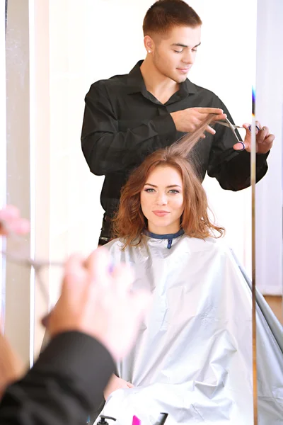 Cabeleireiro jovem fazer penteado menina no salão de beleza — Fotografia de Stock