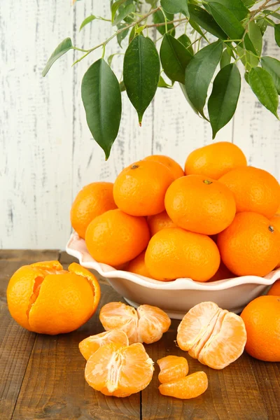 Reife Mandarinen in Schüssel auf Tisch auf Holzgrund — Stockfoto