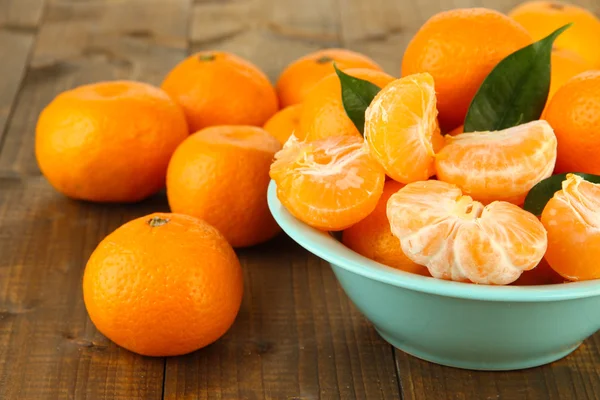 Tangerinas maduras em tigela no fundo de madeira — Fotografia de Stock