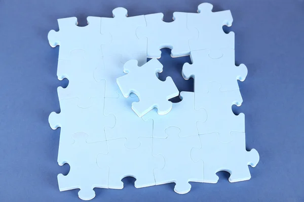 Dernier morceau de puzzle, gros plan, sur fond bleu — Photo