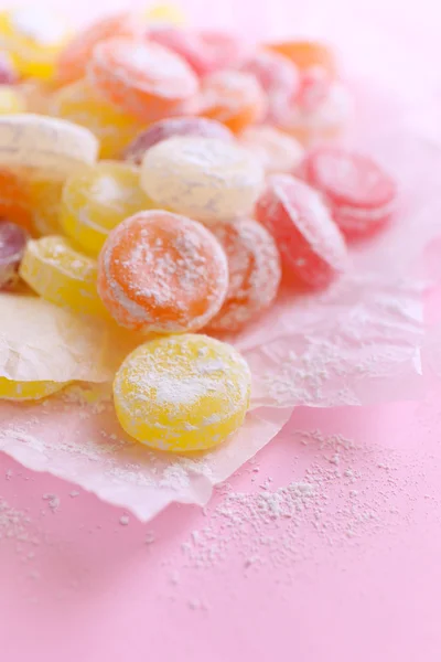 Słodkie cukierki multicolor na papierze, na kolor tła — Zdjęcie stockowe