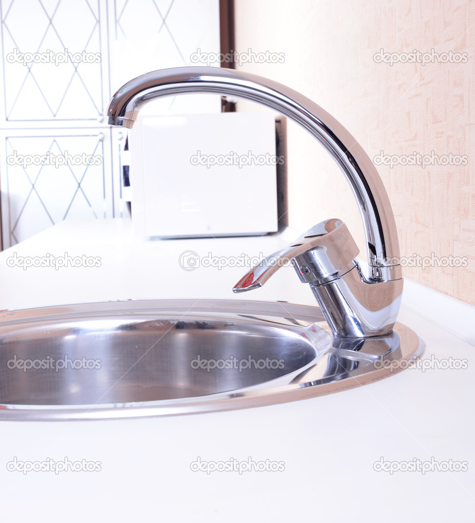 Water tap and sink in modern kitchen