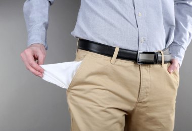 adam boş cebindeki gri arka plan üzerinde gösterilen