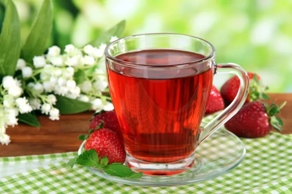 Delicious strawberry tea on table on bright background — Stock Photo, Image