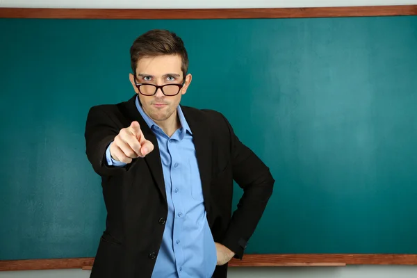 Jonge leraar in de buurt van schoolbord in school klas — Stockfoto