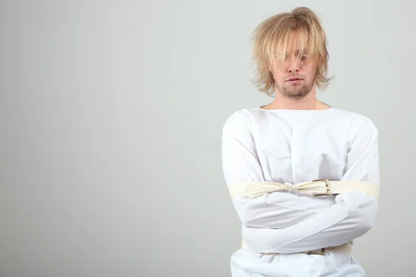 Hombre mentalmente enfermo con camisa de fuerza sobre fondo gris — Foto de Stock