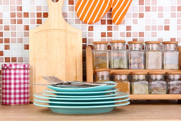 Placas na cozinha na mesa em azulejos mosaico fundo — Fotografia de Stock