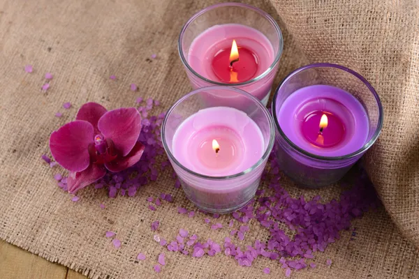 Composición con hermosas velas de colores, sal marina y flores de orquídea, sobre fondo de madera — Foto de Stock