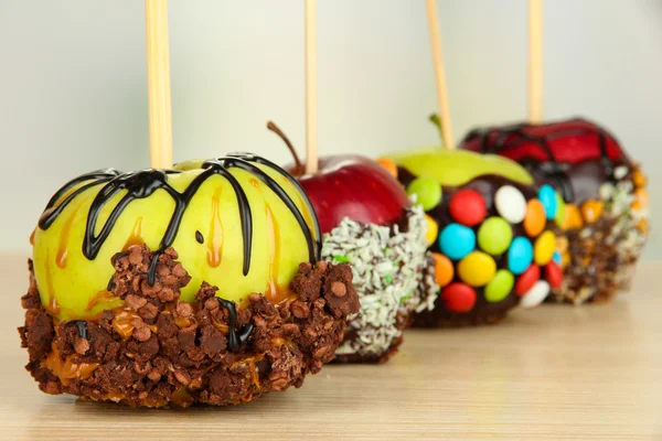 Candied apples on sticks on wooden table close up — Stock Photo, Image