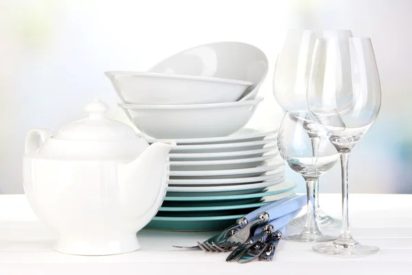 Clean dishes on table on bright background — Stock Photo, Image