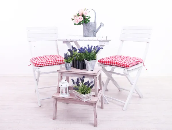 Sillas de jardín y mesa con flores sobre soporte de madera sobre fondo blanco — Foto de Stock