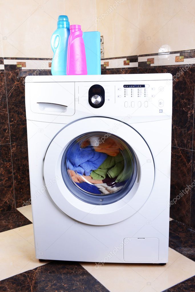 Washing machine loaded with clothes in bathroom