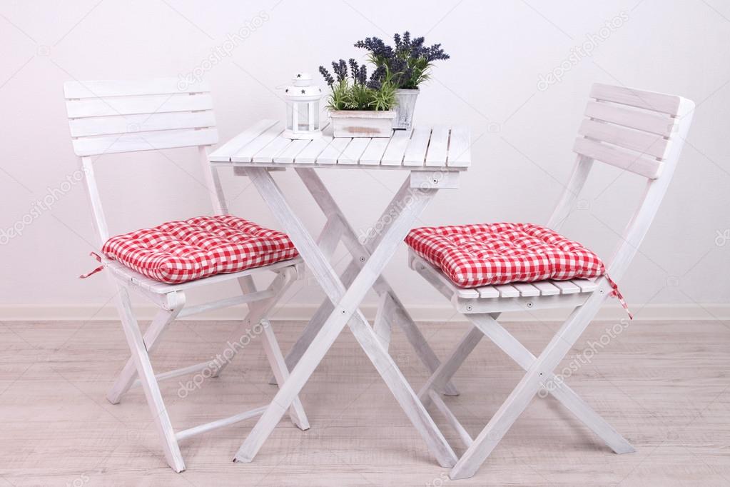 Garden chairs and table with flowers on white background