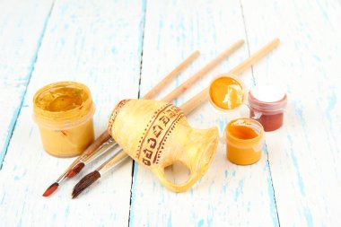el yapımı ahşap masanın üzerine seramik amfora ve renk boyalar