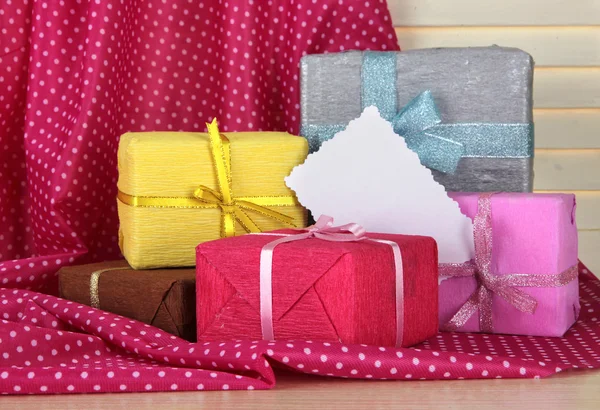 Cajas de regalo con etiqueta en blanco en la mesa sobre fondo de tela — Foto de Stock