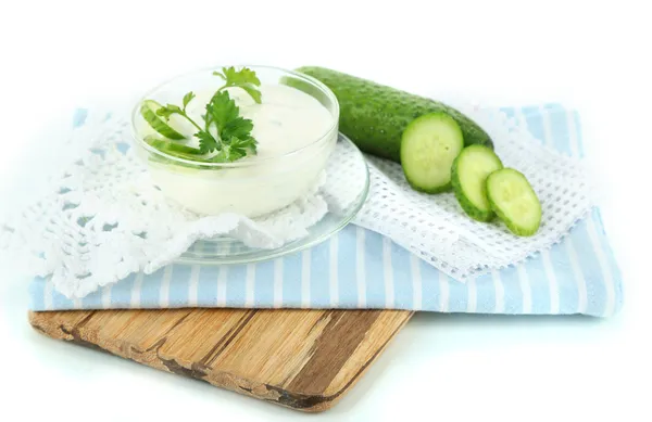 Komkommer yoghurt in kom, op houten bord, geïsoleerd op wit — Stockfoto