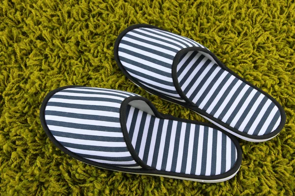 Zapatillas a rayas sobre fondo de alfombra —  Fotos de Stock