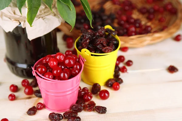 Cranberry fresco e seco em baldes em mesa de madeira close-up — Fotografia de Stock