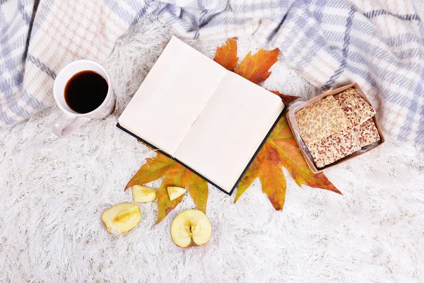 Komposition mit warmem Karo, Buch, Tasse Heißgetränk, auf farbigem Teppich Hintergrund — Stockfoto