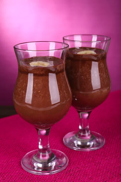 Cocktails with banana and chocolate on table on purple background — Stock Photo, Image