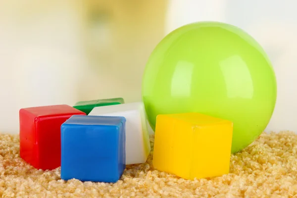 Luminosa palla e cubi colorati su tappeto su sfondo luminoso — Foto Stock
