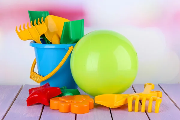 Bright ball and sandbox toys on table on bright background — Stock Photo, Image