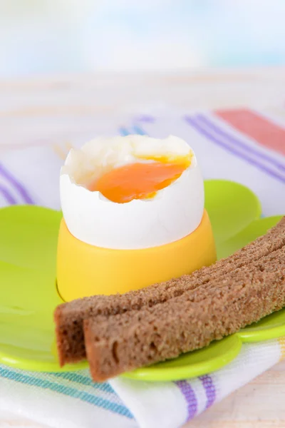 Gekochtes Ei im Eierbecher auf dem Tisch auf hellem Hintergrund — Stockfoto