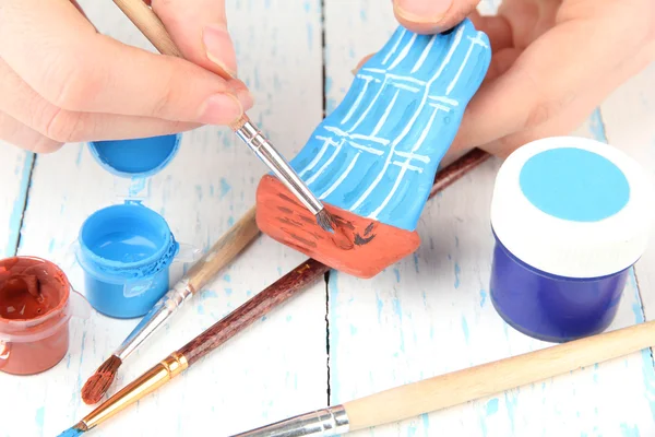 Hands paints on hand made ceramic ship and art materials — Stock Photo, Image