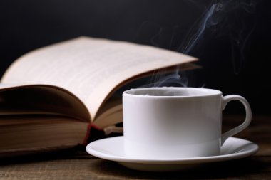 sıcak kahve ile masaya koyu arka plan üzerinde kitap