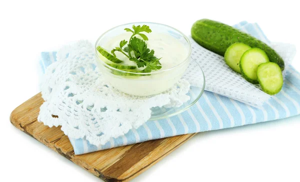 Komkommer yoghurt in kom, op houten bord, geïsoleerd op wit — Stockfoto