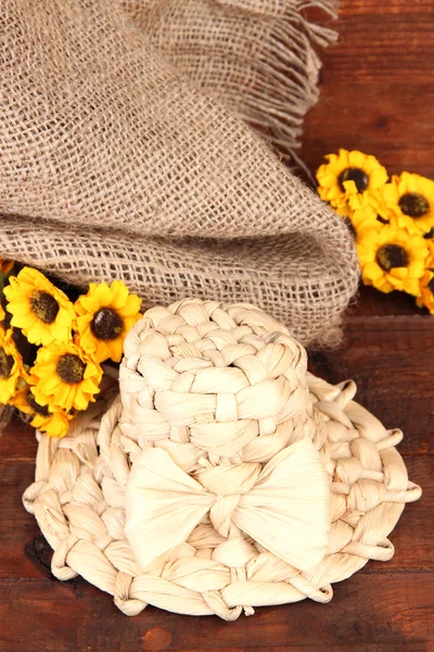 Sombrero de paja pequeño con flores, sobre mesa de madera —  Fotos de Stock