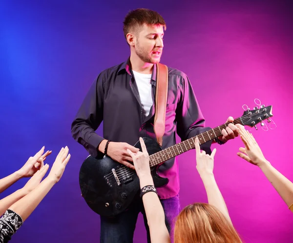 Гитарист поет на сцене на рок-концерте для своих поклонников — стоковое фото