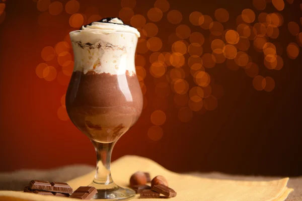 Leckeres Dessert mit Schokolade, Sahne und Orangensoße, auf Holztisch, auf Lichterhintergrund — Stockfoto