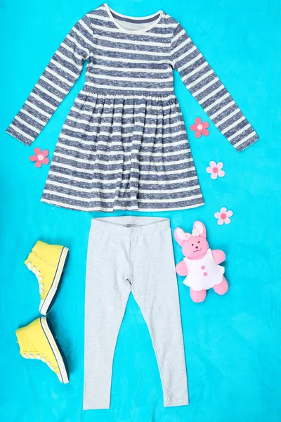 Bei vestiti per la bambina su sfondo blu — Foto Stock
