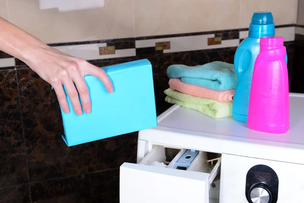 Женские руки наливают порошок в стиральную машину крупным планом — стоковое фото
