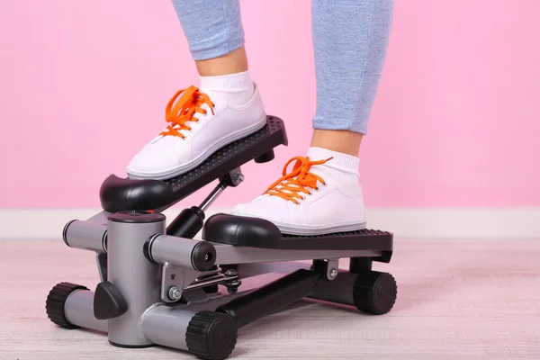 Woman doing exercise on stepper. Close-up on legs. — Stock Photo, Image