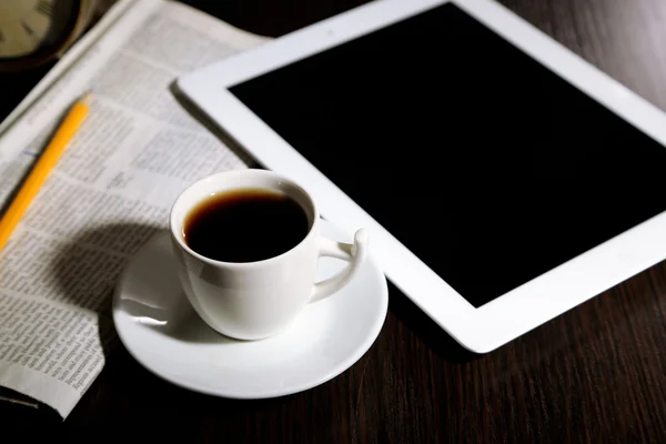 Tablet, noviny, šálek kávy a budík na dřevěný stůl — Stock fotografie