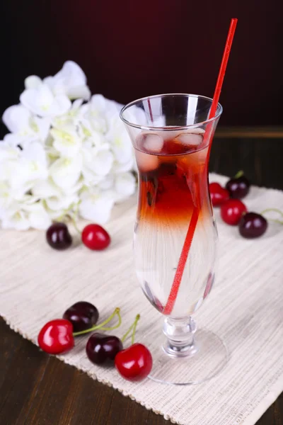 Glass of cocktail on table on dark red background — Stock Photo, Image