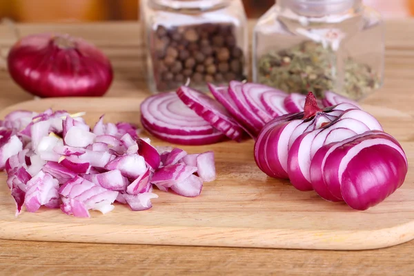 Wyciąć cebuli na deska do krojenia na drewniane tła — Zdjęcie stockowe