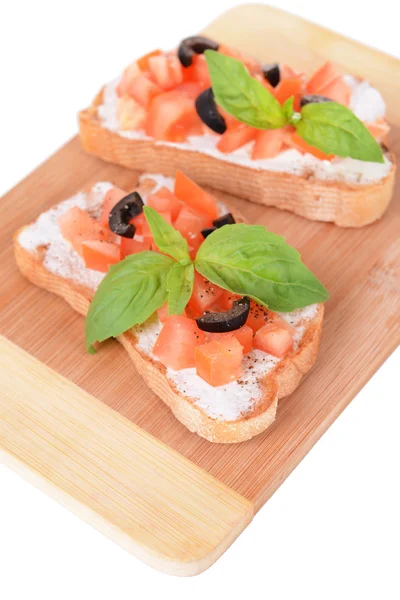 Deliciosa bruschetta con tomates en tabla de cortar aislada en blanco — Foto de Stock