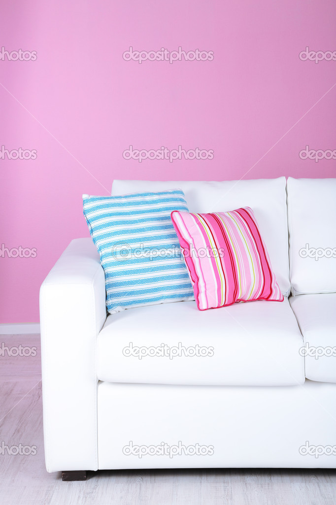 White sofa close-up in room on pink background
