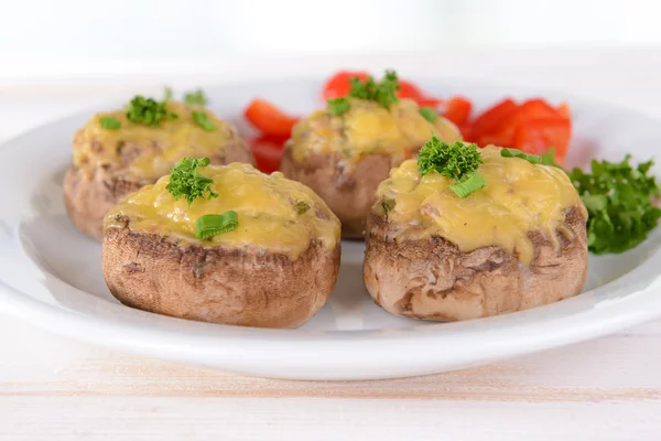 Champiñones rellenos en plato sobre mesa sobre fondo claro — Foto de Stock