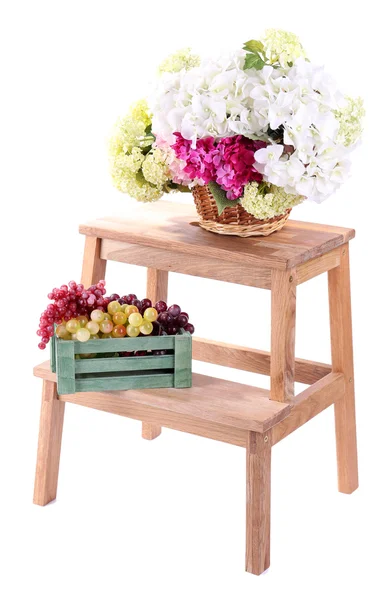 Rieten mand met bloemen en vruchten in houten doos, op kleine houten ladder, geïsoleerd op wit — Stockfoto