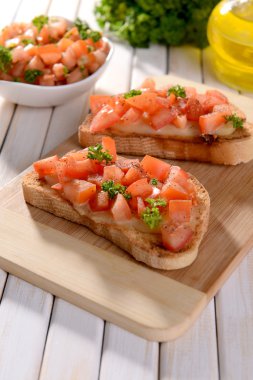 Kesme tahtasında domatesli lezzetli bruschetta.