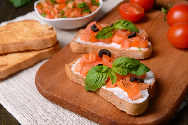 Finom bruschetta paradicsommal a vágódeszkán közelkép — Stock Fotó