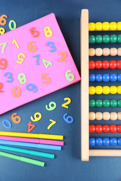 Kleurrijke getallen, abacus, boeken en markeringen op school Bureau achtergrond — Stockfoto