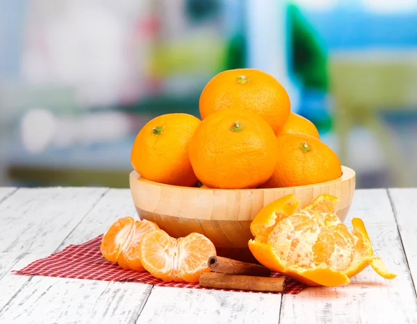Mandarinas dulces maduras con especias en un tazón, en una servilleta, sobre un fondo brillante — Foto de Stock