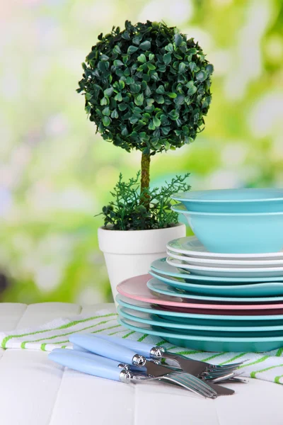 Platos limpios con flores sobre mesa de madera sobre fondo natural — Foto de Stock