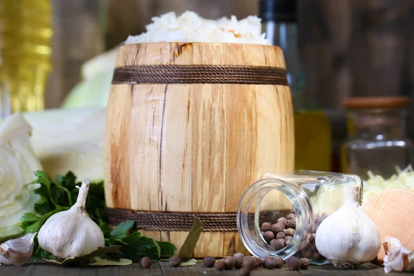 Composition au chou frais et mariné (choucroute) en fût de bois, sur fond de table en bois — Photo